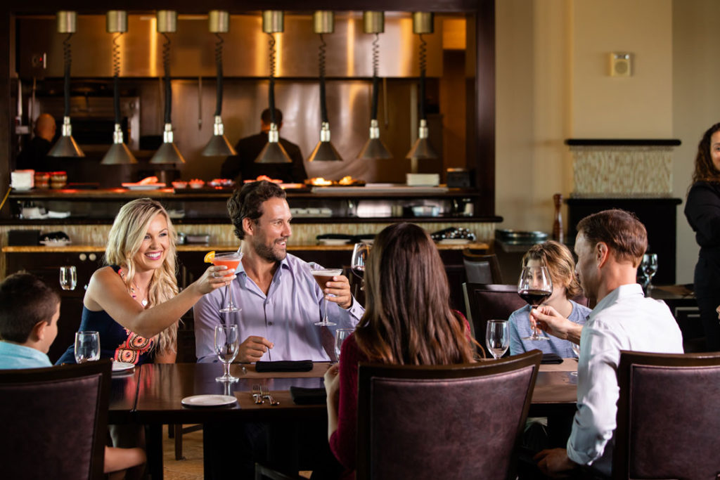 Family raises their drink glasses in a toast at Traditions restaurant.