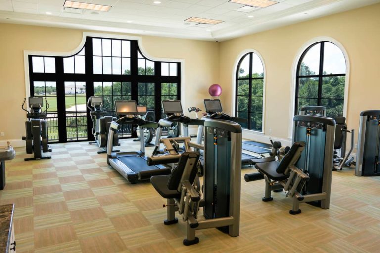 Fitness room at the Bear’s Den Resort Orlando’s Nicklaus Clubhouse, with large windows offering expansive views of the Jack Nicklaus golf course.