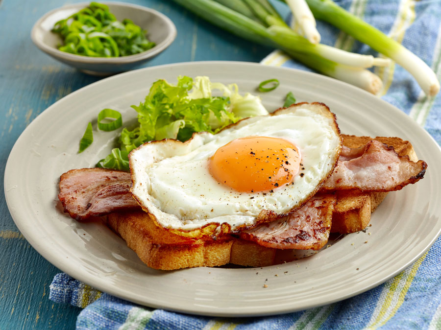 Fried egg sandwich with bacon and lettuce.