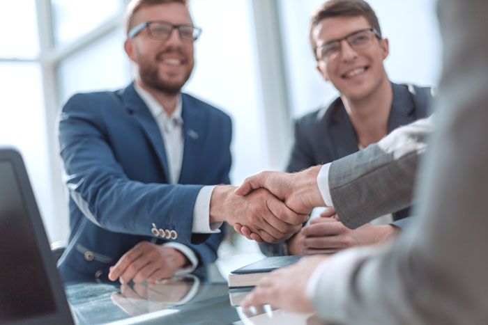 Two people shake hands during a business meeting.