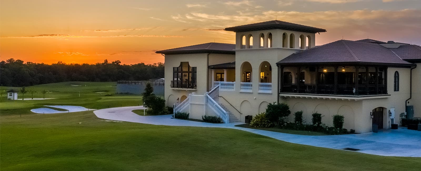 Sunset view of the Jack Nicklaus golf course and clubhouse at The Bear’s Den Resort Orlando.