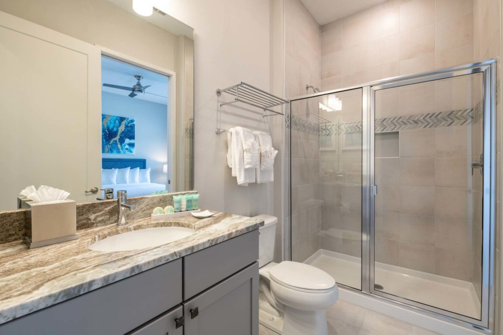 Bathroom with shower, toilet, and sink in an elegant 8-bedroom Bear’s Den Resort Orlando residence.