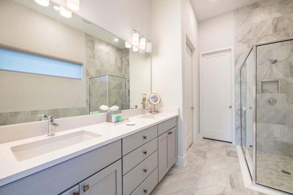 Large bathroom with double sink, mirror, and standing shower in an elegant 8-bedroom Bear’s Den Resort Orlando residence.