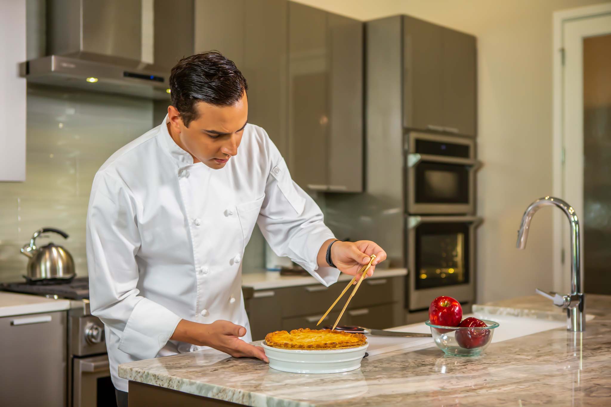 An expert chef prepares a meal during an in-home chef experience.