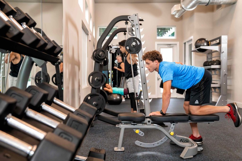Man working out on exercise equipment in the Bear’s Den fitness center.