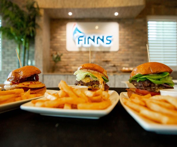Finns burgers and fries on plates.