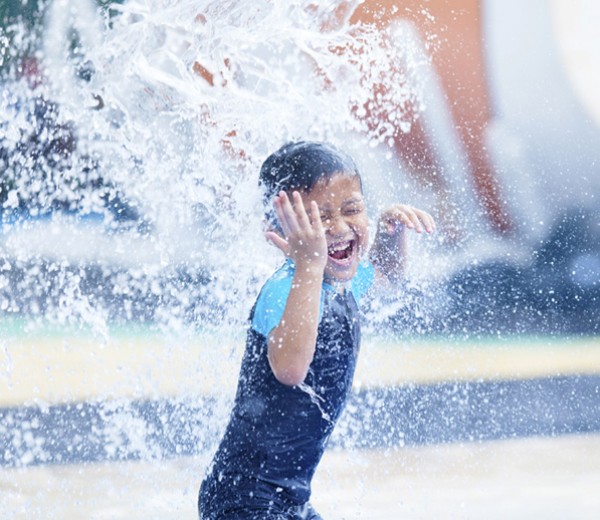 Young boy splashing at the water park.