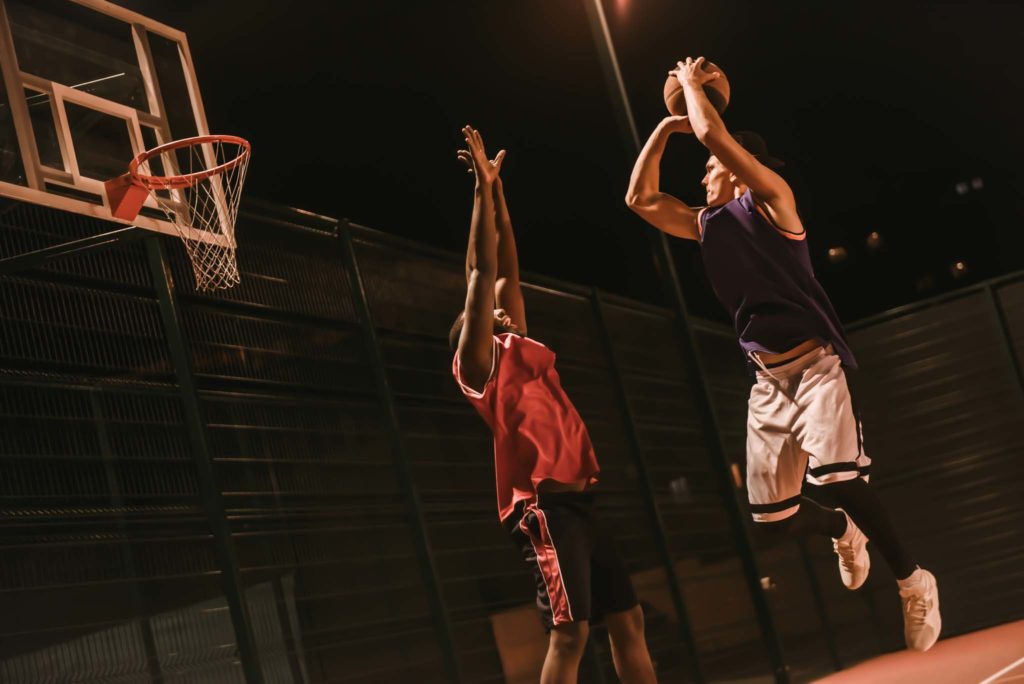Dos hombres jugando baloncesto.