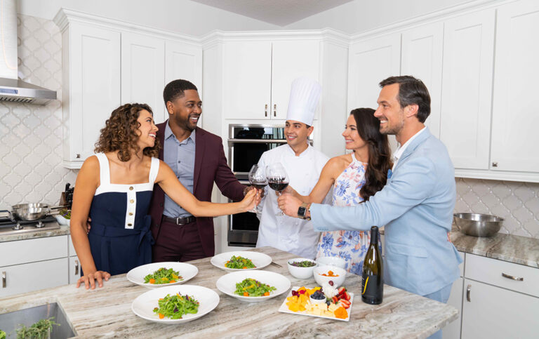 Friends toasting in a kitchen with a private chef