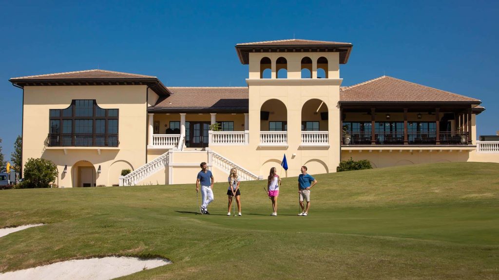 Group playing golf in front of the Clubhouse at Bear's Den