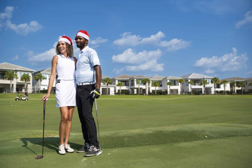 Couple in Santa Claus hats golfing on the Jack Nicklaus Course