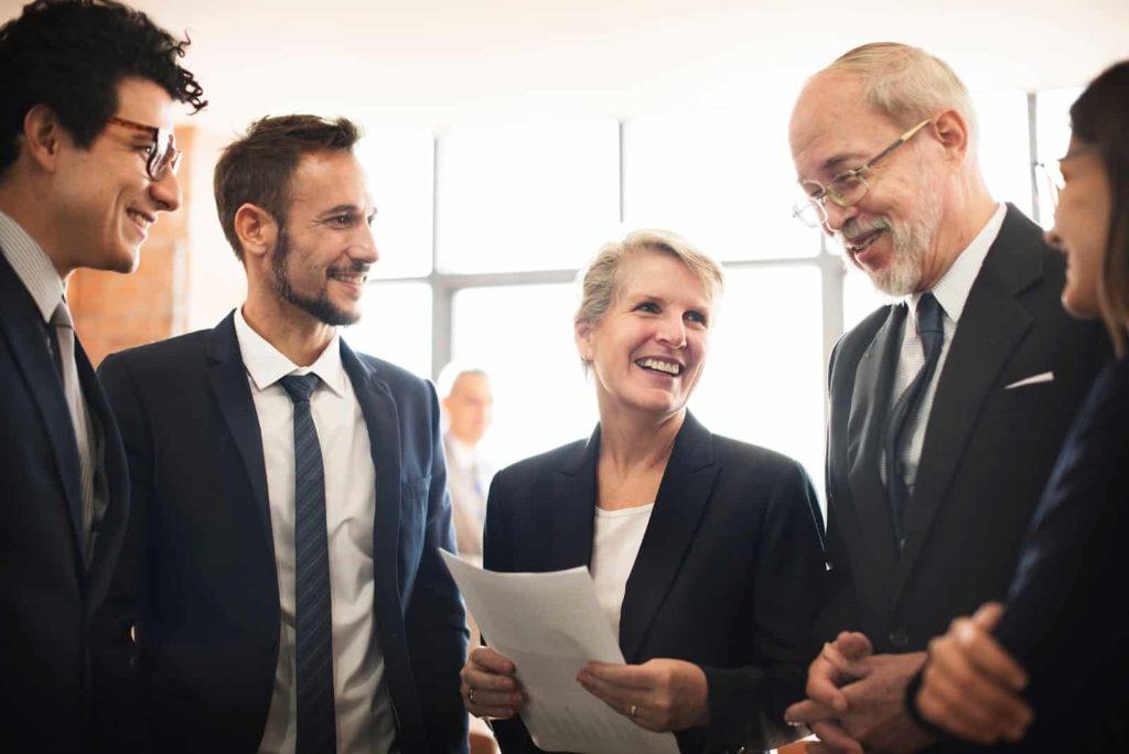 Group of people smiling and talking during a event meeting.