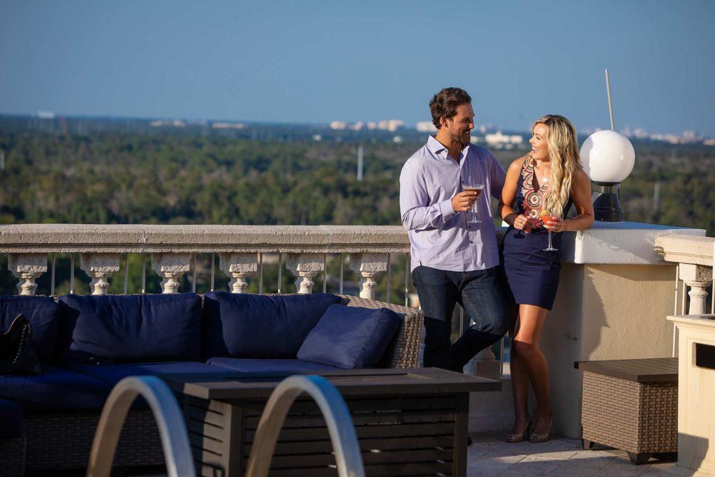 Couple enjoying cocktails on a balcony with a view