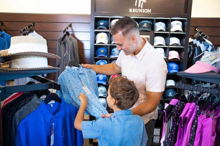 Father and son shopping at a golf store.