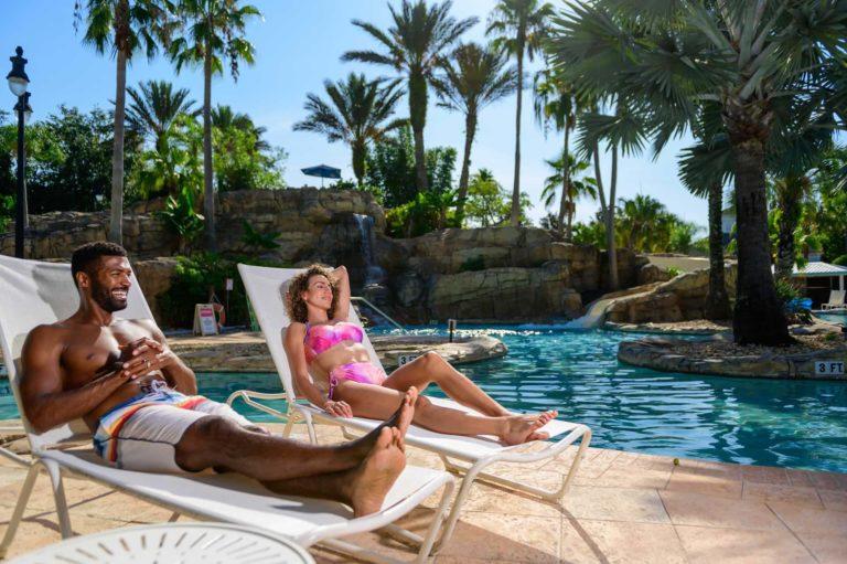 Couple relaxing in lounge chairs at the water park | Bear's Den Resort Orlando