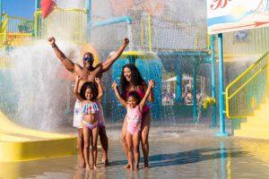 Happy family of four getting splashed by the bucket at the Encore Resort water park