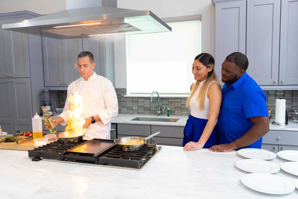 Chef flambeing a meal while a couple watches as part of the Chef Experience at Bear's Den Resort