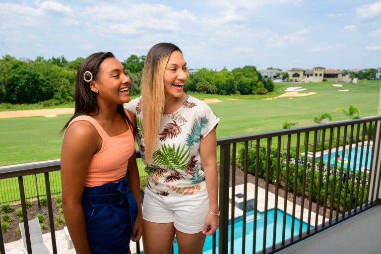 Madre e hija riéndose en el balcón de su casa en Bear's Den Resort