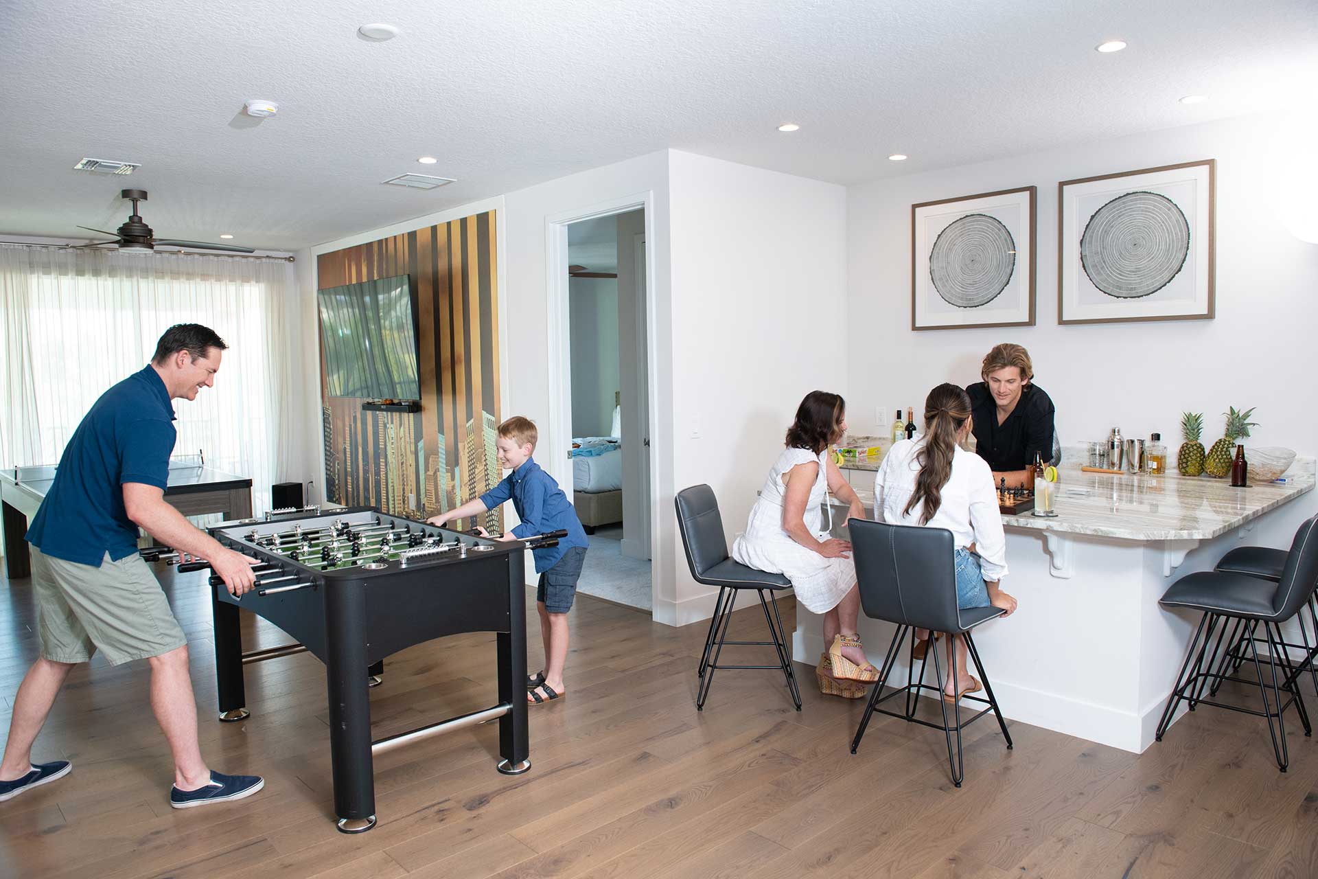 Group playing foosball and board games in their Bear's Den Resort home game room.