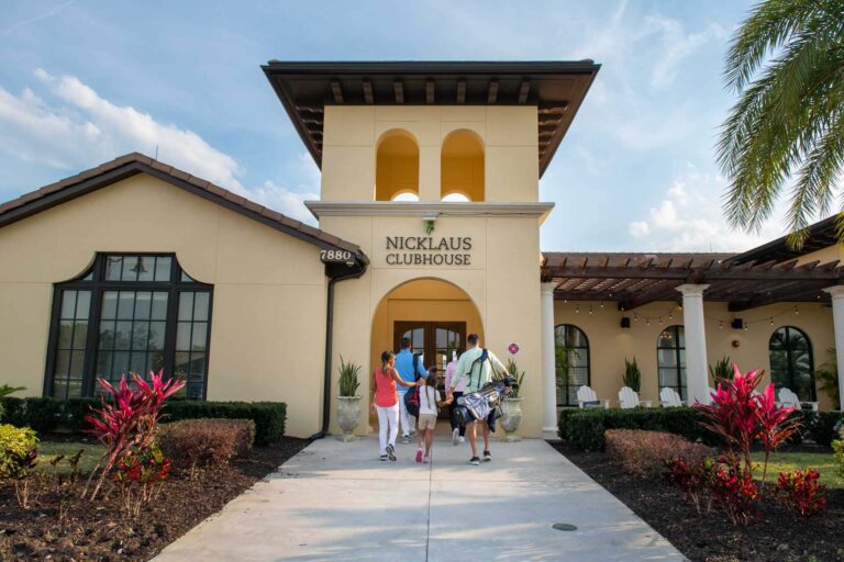 Group walking into the Jack Nicklaus Clubhouse with golf gear at the Bear's Den Resort Orlando