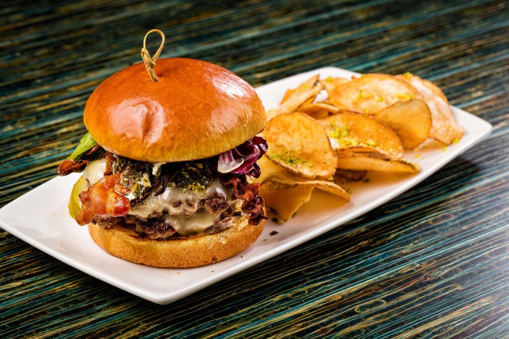 Bacon cheeseburger served with a side of chips at Finns Restaurant | Encore Resort at Reunion