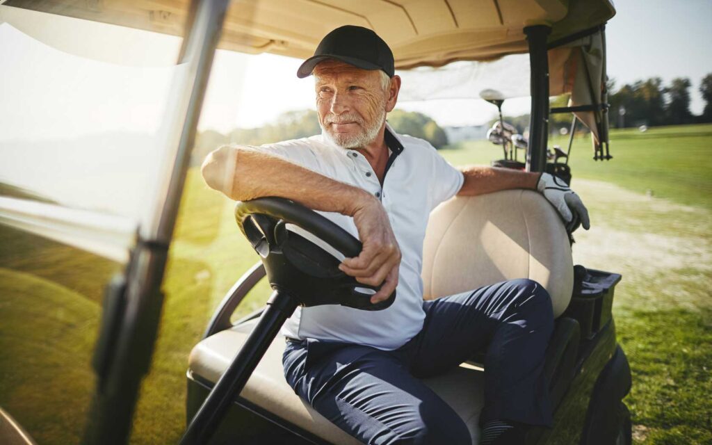 Anciano conduciendo un carrito de golf en Reunion Resort