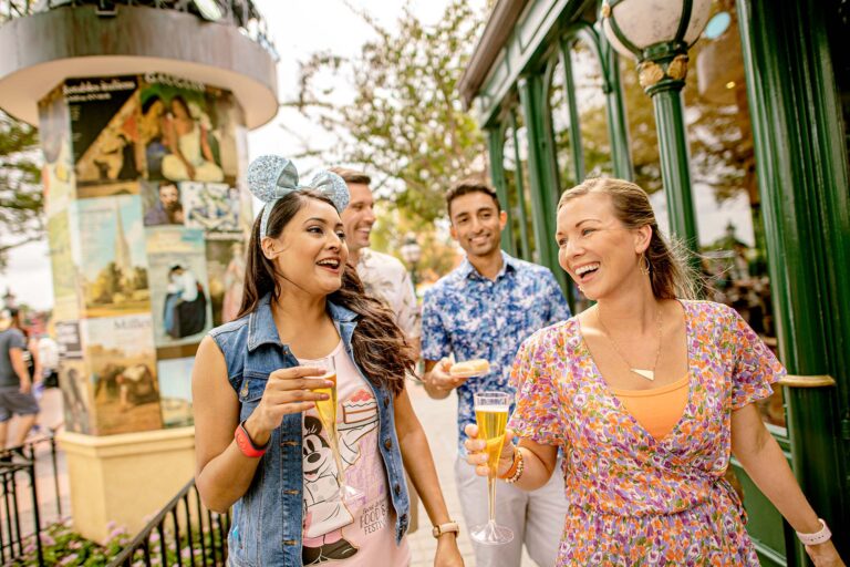 Group of friends walking around the EPCOT Food and Wine Festival with food and drinks