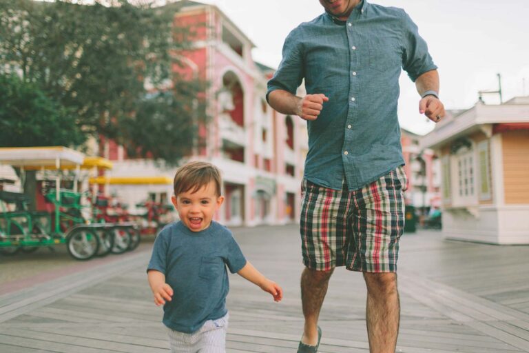 Father and son running on the boardwalk at Disney's Boardwalk Resort | Walt Disney World
