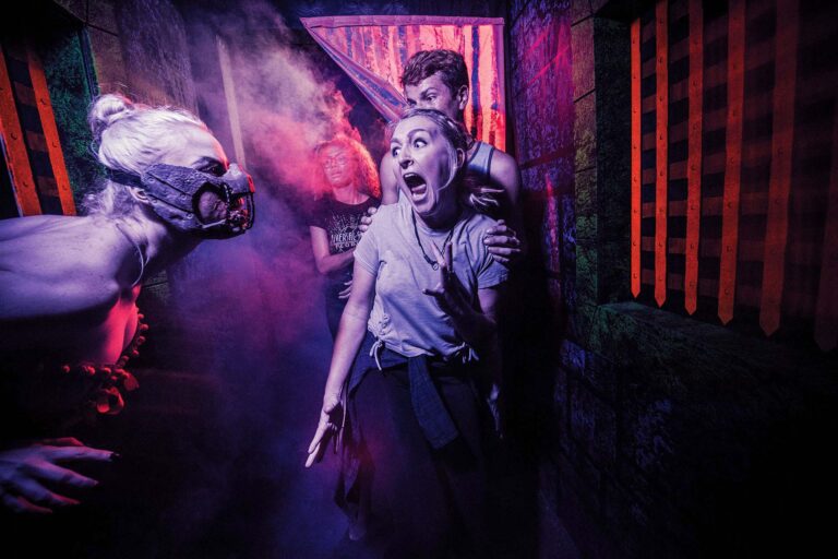 Monster scaring a group of friends at Universal's Halloween Horror Nights in Orlando, Florida