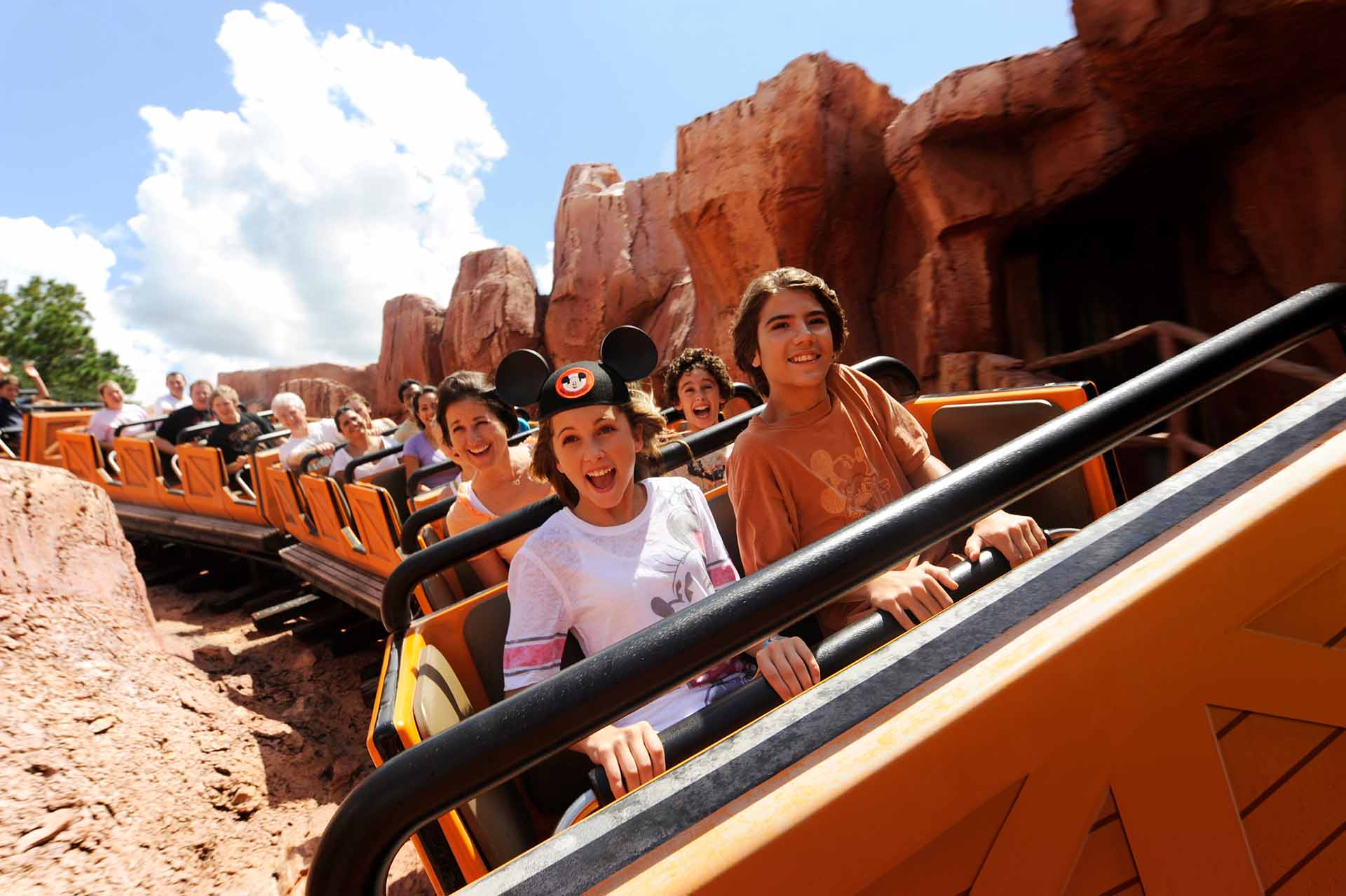 Group of people riding on the Big Thunder Mountain Railroad roller coaster at the Magic Kingdom