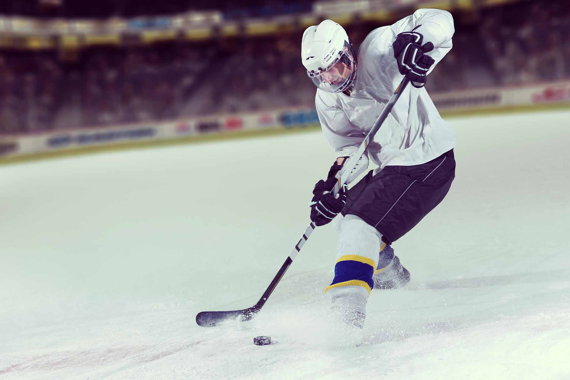 Jugador de hockey sobre hielo a punto de golpear el disco