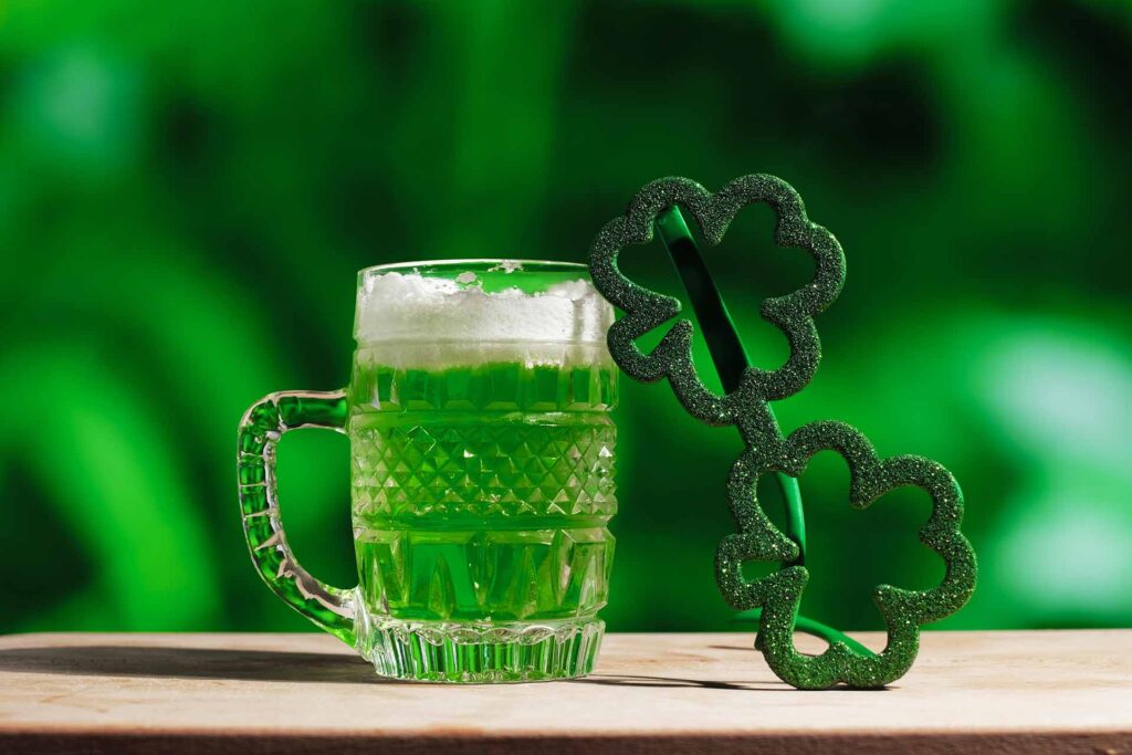 Glass of green beer and Shamrock glasses