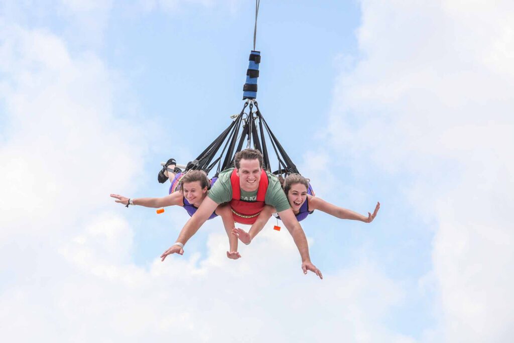 Father and daughters riding the Sky Coaster in Fun Spot America in Kissimmee, Florida
